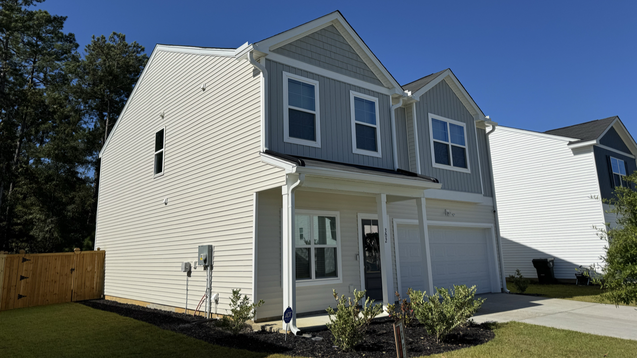 Two-story gray home with new white gutters and downspouts