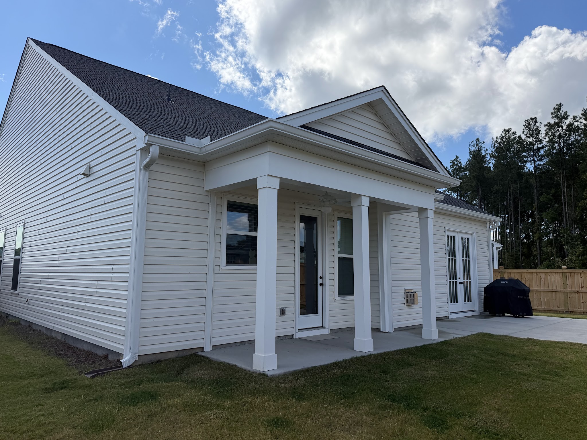 White vinyl-sided home with a columned porch and new gutters