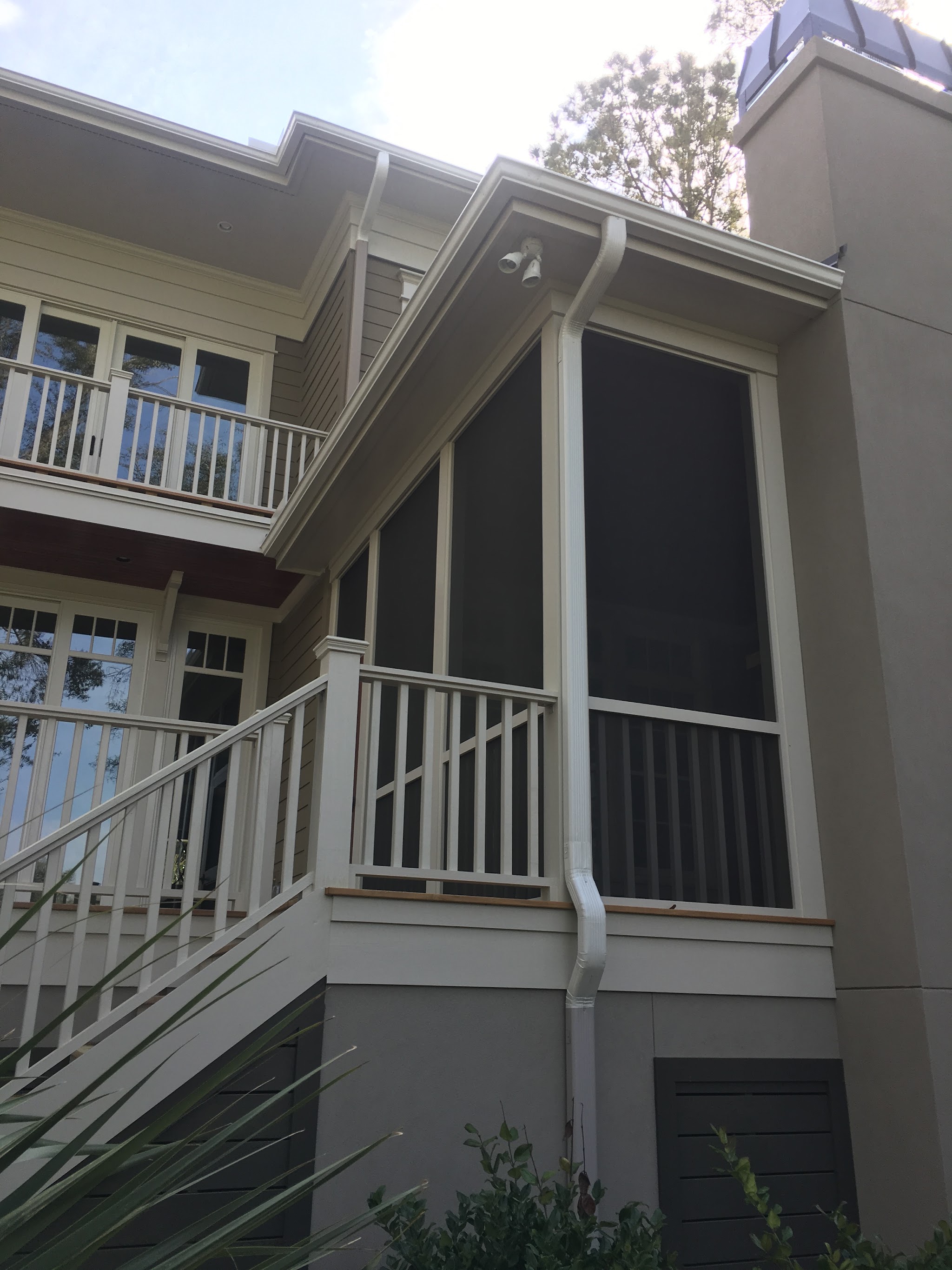 White downspout running down the corner of a screened porch