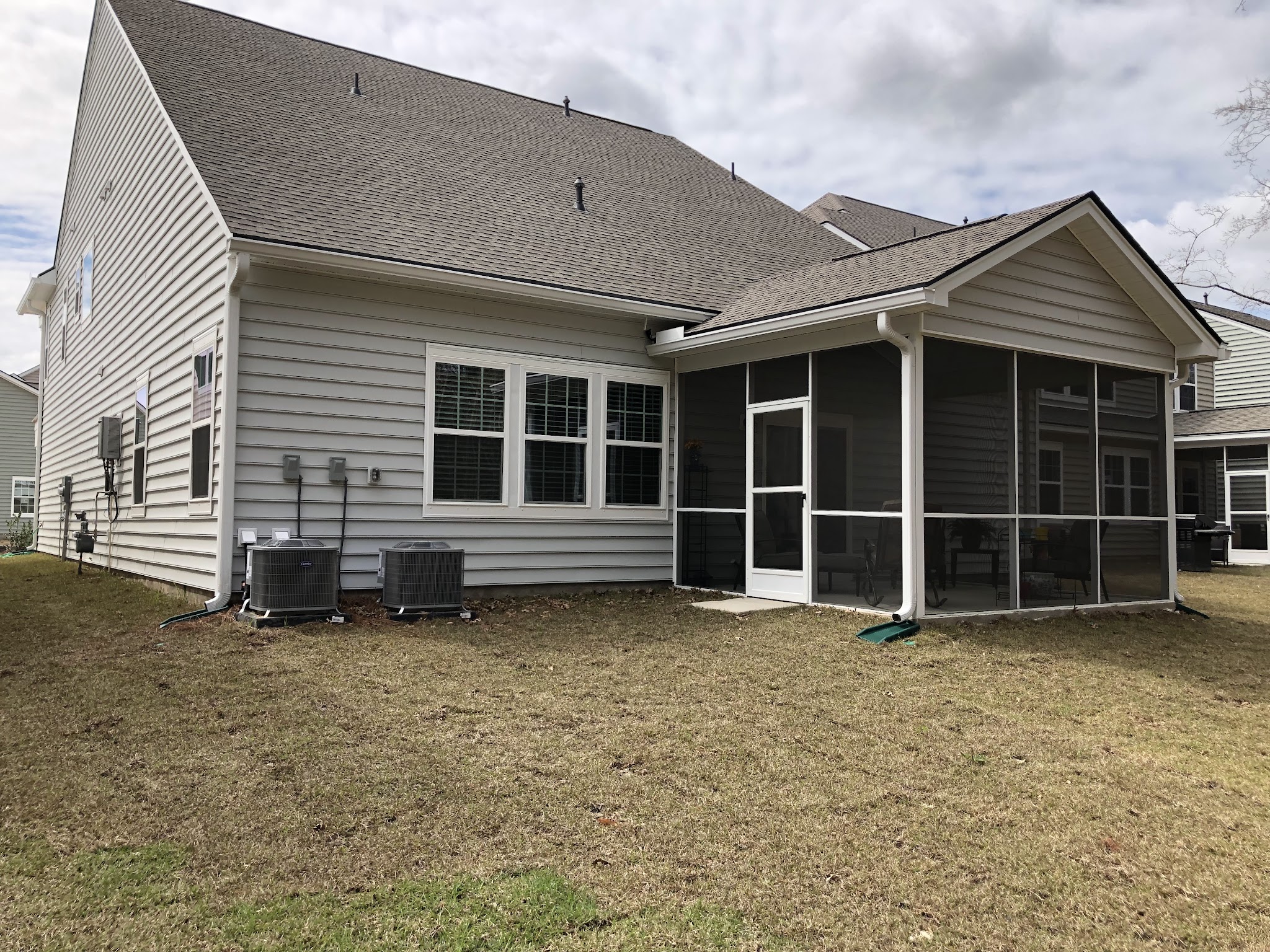 Back of a home with a screened porch and downspouts